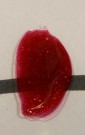 Bilde av fargeprøve tatt i lampelys, hvitt ark med sort tusjstrek som bakgrunn for å vise dekkevne. thumbnail